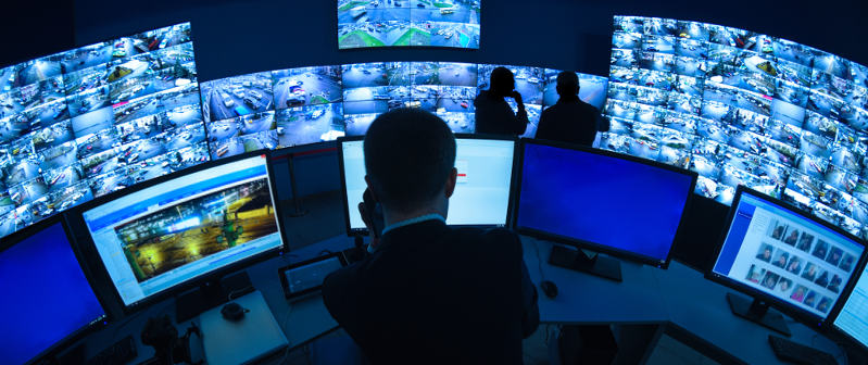 man watching surveillance on monitors